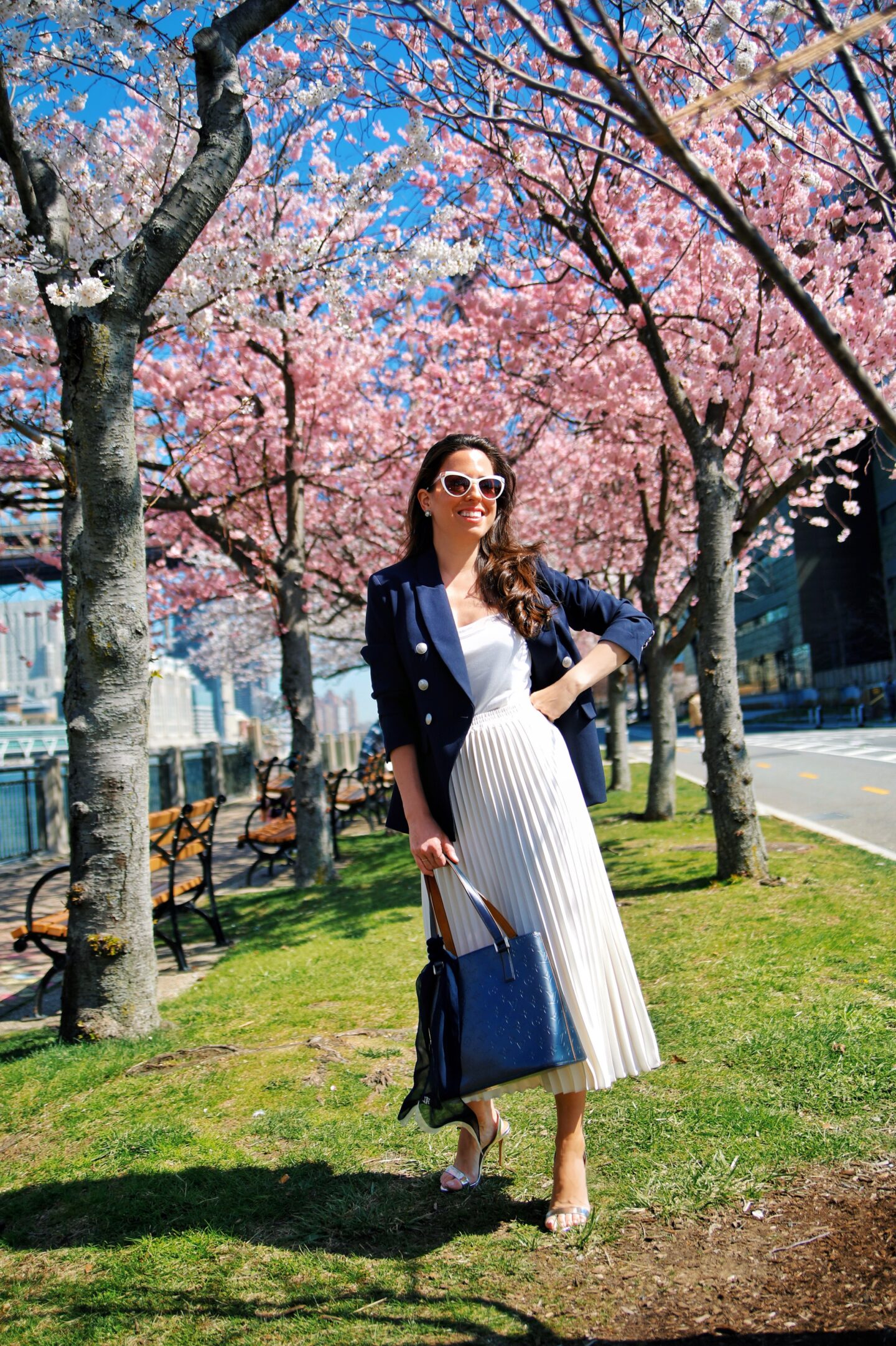 Ana Florentina wearing navy blazer and white pleated skirt spring outfit 